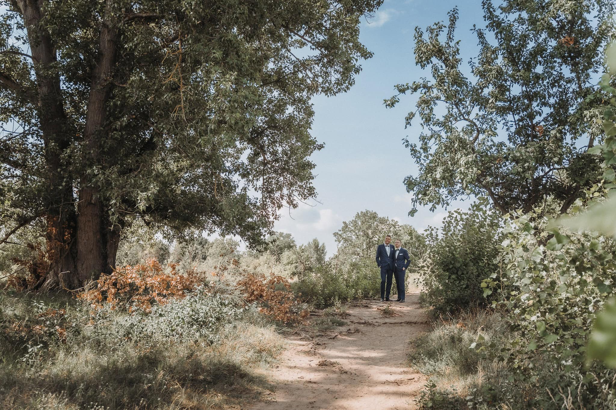 Zwei Bräutigame in eleganten Anzügen beim Weddingshoot Gay Wedding LGBTQ